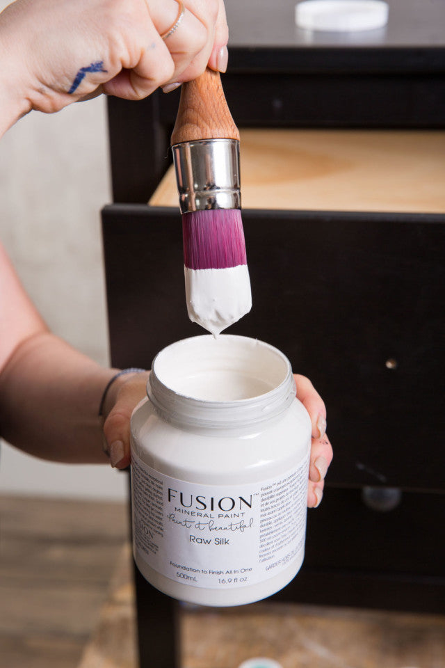 Dipping a paint brush into a premium paint without it dripping