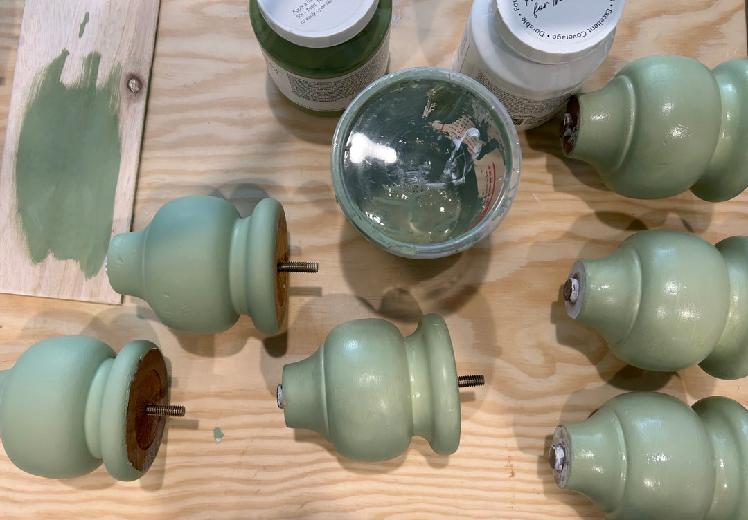 Custom-mixed mint green paint and nightstand legs laid out during the furniture refinishing process in the studio