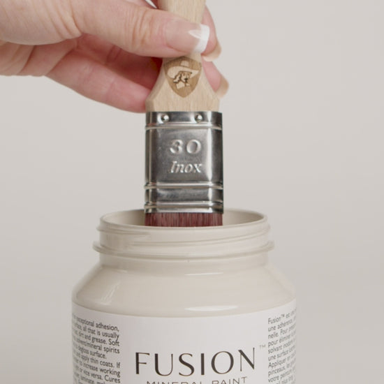 Video of women dipping wooden paint brush into pint of Fusion Mineral Paint Pint named Chateau