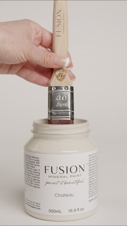 Video of women dipping wooden paint brush into pint of Fusion Mineral Paint Pint named Chateau